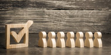 Ahşap insan figürleri birlikte bir onay kutusunun yanındaki bekletin. Seçimler ve sosyal teknolojileri kavramı. Gönüllüler, partiler, adaylar, seçim electorates. İnsan hakları. referandum