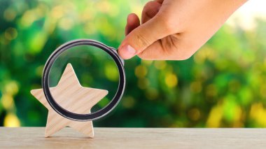 Bir ahşap yıldız. Otel, Restoran, otel değerlendirme. Genel Bakış. eleştirmen beğenisine. Negatif geri besleme. düşük kaliteli hizmet. yeşil bokeh arka plan. seçici odak