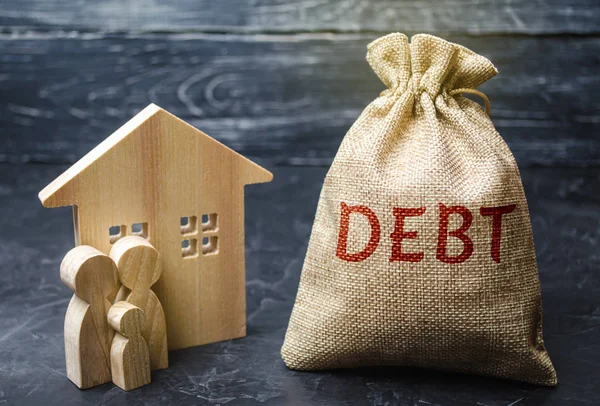 A bag of money with the word Debt and the family standing near the house. The concept of debt for housing. Mortgage. Real estate, home savings, loans market concept. Risks of buying a house.