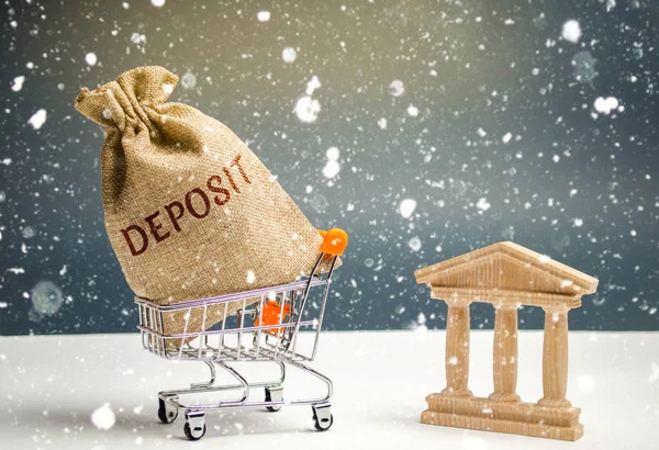 Bag with money and the word deposit with bank building. The concept of the New Year\'s deposit. New Year\'s interest rates. Promotion Convenient and profitable offers. Christmas and seasonal deposits