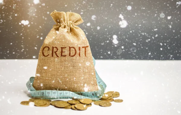 Bag with money and tape measure and the word Credit. Christmas Loans. Low interest rates. Favorable offers for borrowers. Consumer loan. Loan protection insurance. New Year Promotions