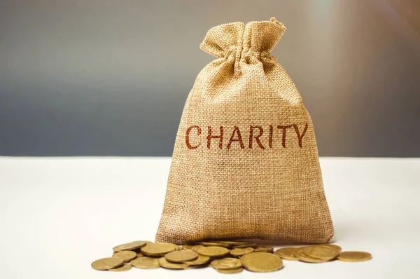 Bag of money and the word Charity. The concept of accumulating money for donations. Saving. Social medical help from volunteers. Charitable foundation