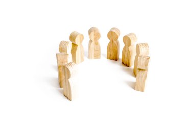 Wooden figures of people stand on a white background. Communication. Business team, teamwork, team spirit. Wooden figures of people. A circle of people. The concept of discussion