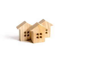 Beyaz arka planda tahta ev figürleri. Minimalizm ve kopyalama alanı. Ev ve gayrimenkul yatırımları. Gayrimenkul, konut, alım-satım, kiralama kavramı. Yerleşim ya da topluluk