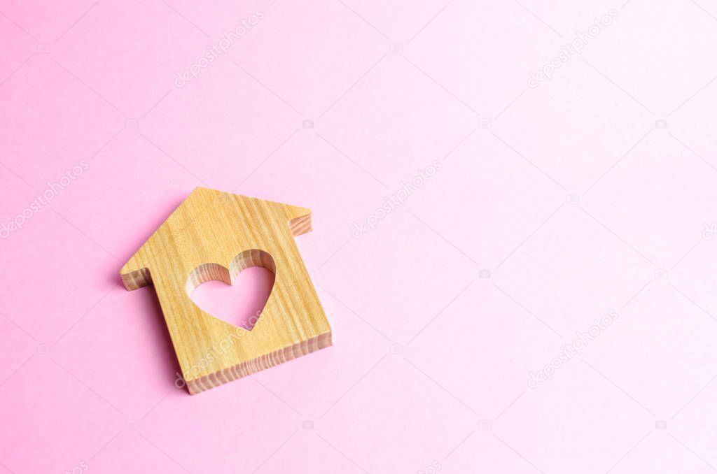 House with a heart on a pink background. The concept of finding a rental house or apartment for a romantic pastime. Valentine's Day. Affordable housing for couples lovers. Shared housing, new life.