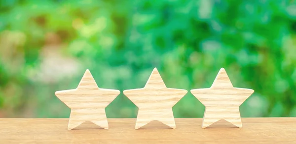 Three wooden stars. The rating of the hotel, restaurant, mobile application.The concept of rating and evaluation. Quality service, buyer choice. Success in business