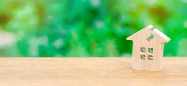 A wooden house with a crack. The concept of a damaged house, dilapidated housing. Renovation, repair and restoration of the old building. Property insurance. Weather element. Damage. — Stock Image Wooden House Crack Concept Damaged House Dilapidated Housing Renovation Repair Royalty Free Stock Images