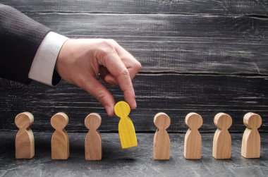 Elini bir işadamı bir adam ahşap bir rakam tutuyor. İşe alma ve işçiler, promosyon ateş arama kavramı. İş taktik ve strateji, yönetim, işletme yönetimi.