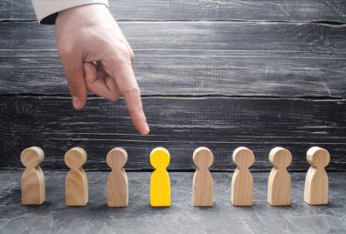 Bir işadamı el ahşap bir insan figürü için işaret eder. İşçiler, aratmak insan kaynakları yönetimi kavramı. İşe alma ve volnenie çalışanları, basınç, işçi hakları ihlali.