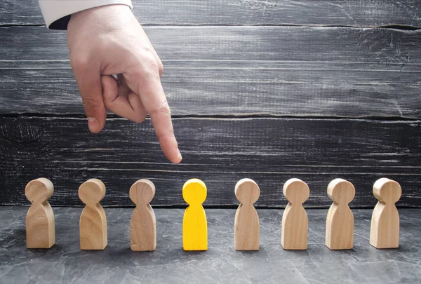 Bir işadamı el ahşap bir insan figürü için işaret eder. İşçiler, aratmak insan kaynakları yönetimi kavramı. İşe alma ve volnenie çalışanları, basınç, işçi hakları ihlali.