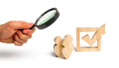 Büyüteç Camı birlikte bir onay kutusunda yanındaki üç ahşap insan figürleri standında arıyor. Seçimler ve sosyal teknolojileri kavramı. seçim electorates. İnsan hakları.