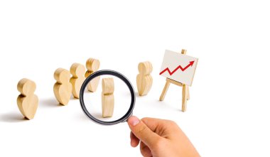 Magnifying glass is looking at the Wooden figures of people stand in the formation and listen to their leader. Business training, briefing and inspirational speech. Employee reports. Selective focus