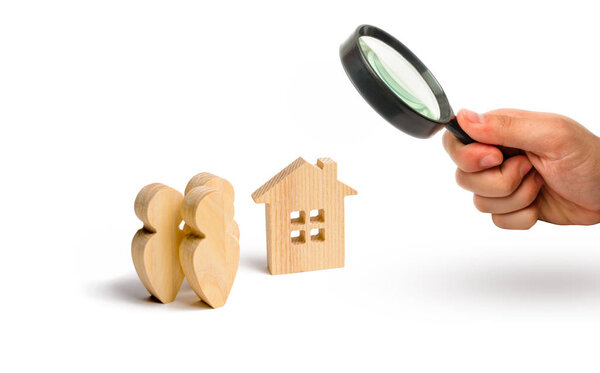 Magnifying glass is looking at the A group of people standing near the apartment building. Lending to buy a house. Ownership Society. Affordable mortgage for young families. Rent or purchase