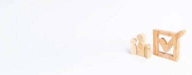 Üç ahşap insan figürleri birlikte bir onay kutusunun yanındaki bekletin. Seçimler ve sosyal teknolojileri kavramı. Gönüllüler, partiler, adaylar, seçim electorates. İnsan hakları. Afiş