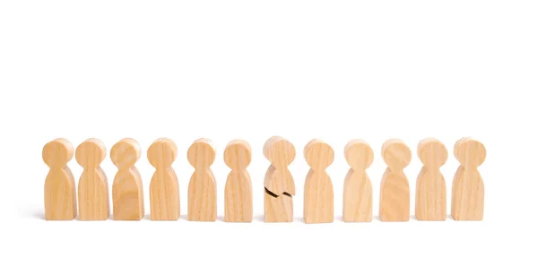 A row of wooden people and a broken figure of a person among them. The concept of a weak link. Did not give up to expectations and did not fulfill the task. Weak player, worker for dismissal.