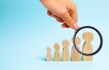 Büyüteç insan figürleri ahşap dan küçük için büyük bir yarım daire tribünde arıyor. Kendini geliştirme, büyüme kişiliği ve profesyonellik kavramı. Çocuklar ve ebeveynler