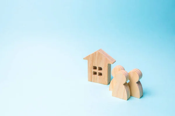 Три Фигуры Людей Деревянный Дом Синем Фоне Концепция Доступного Жилья — стоковое фото