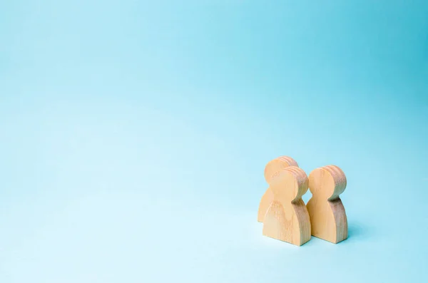 Drie Mensen Eensgezind Praten Twee Houten Figuren Van Mensen Voeren — Stockfoto