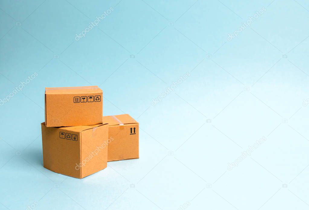 A bunch of boxes on a blue background. The concept of moving to a new home, delivery of goods or commerce. Production, industry and warehousing of goods. import and export. Transportation services.