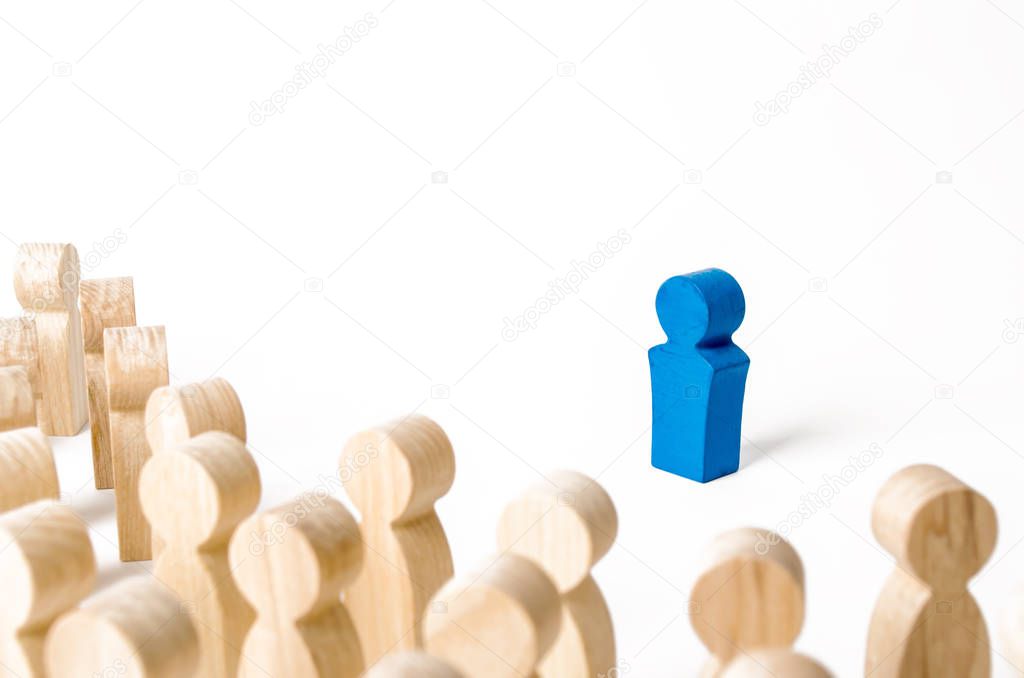 Blue human figurine in the spotlight of a crowd of people. Leader, leadership, head of organization or community. Organization of work and business processes, team building. Idol and example to follow