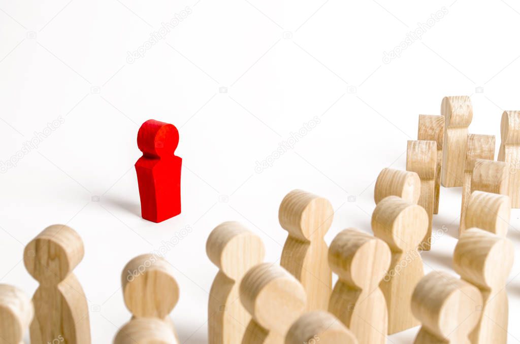 Red figurine of a man in the spotlight of a crowd of people. Leader, leadership and initiator of action. work or business organization. team building. Idol and example to follow. Distrust. Toxicity