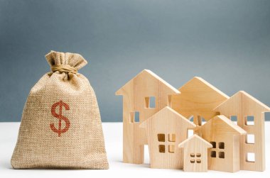 Para ve dolar işareti ve ahşap evler ile çanta. Ülkede finansman. Para gayrimenkul yatırım. Tasarruf ve para birikimi. İpotek. Bir ev satın almak. Mülk satışı. Şehir bütçe.