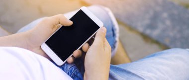 adam bir hareket eden smartphone tutarak ve ekrana bakarak. telefon bağımlılığı, sosyal ağlar. Internet üzerinde çalışma. mesajı yazın. güneşli bir gün. yakın çekim, metin için yer