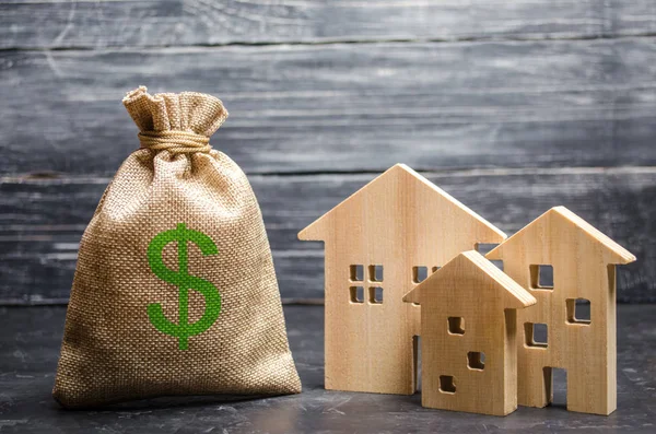 Una borsa con soldi e tre case. Concetto di acquisizione e investimento immobiliare. Prestito a buon mercato, ipoteca. Tasse, redditi da locazione. Costruire case. Bilancio comunale della comunità . — Foto Stock