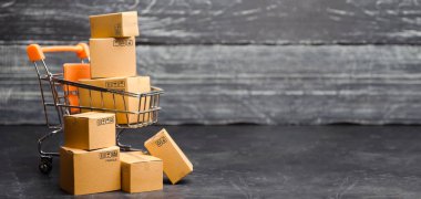 Kutuları olan el arabası süpermarketi. Ürün satışları. Konsept ticareti, online alışveriş. E-ticaret, satış ve satış çevrimiçi ticaret platformları aracılığıyla. Satın alma gücü, teslimat emri.