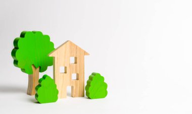 Ağaçlar ve çalılarla çevrili ahşap çok katlı bir bina. Kentselcilik ve kentsel peyzaj. İpotekli konutların satın alınması. Genç aileler için kalacak yer. Kiralık daireler
