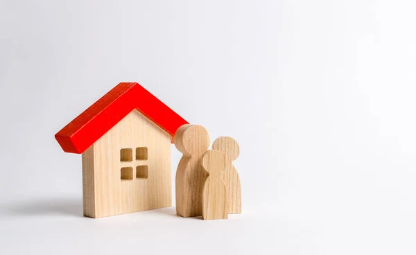 Figuras de la familia y la casa sobre un fondo blanco. bienes raíces, su propia casa. Comprando o vendiendo. Vivienda asequible a crédito o hipoteca. Renovación y construcción. Subvenciones, ciudadanía . —  Fotos de Stock