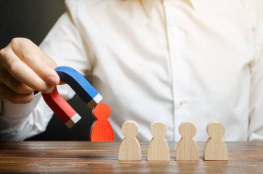 İşadamı mıknatıslı takımdan kırmızı bir figür çiziyor. Toksik ve yetkin olmayan işçi kavramı. Ekip verimliliğini ve üretkenliğini artırın. lider iş yönetir ve bir ekip oluşturur.