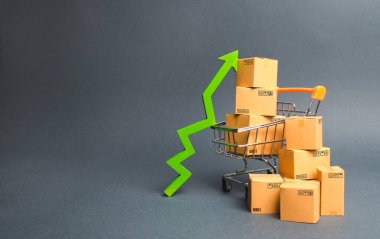 Karton kutular ve yeşil yukarı ok ile alışveriş sepeti. Mal satış ve üretim hızını artırın. Tüketici duyarlılığının iyileştirilmesi, ekonomik büyüme. Geliri artırma stratejisi