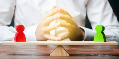 Bir kilit jest elleri ile bir adam ve bir ölçekler üzerinde kırmızı ve yeşil standoff rakamlar bakar. uyuşmazlık çözümü ve uyuşmazlıkta uzlaşma arayışı. Düşünceli karar