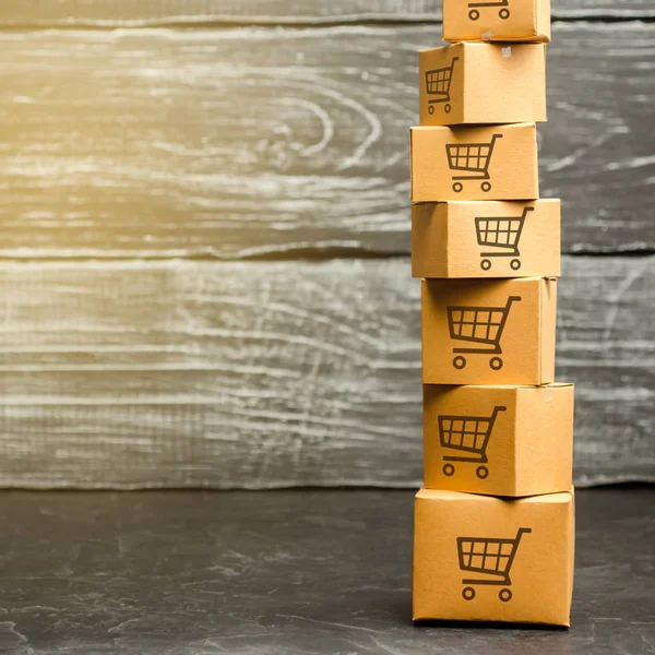 Tower of cardboard boxes with pattern of shopping carts. Purchasing power, delivery order. E-commerce, logistics, distribution. commerce, online shopping. Sales of goods and services. Copy space — Stock Photo, Image