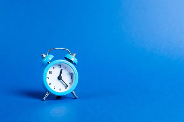 青い背景に青い目覚まし時計。限られたオファーと時間をかけて。計画と規律。会議を待っています。時間 厳守。事業計画。寿命と健康、あなたの年齢を増加させます. — ストック写真