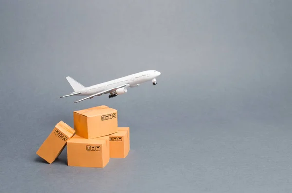 Airplane and stack of cardboard boxes. concept of air cargo and parcels, airmail. Fast delivery of goods and products. Cargo aircraft. Logistics, connection to hard-to-reach places. Air fleet supply.
