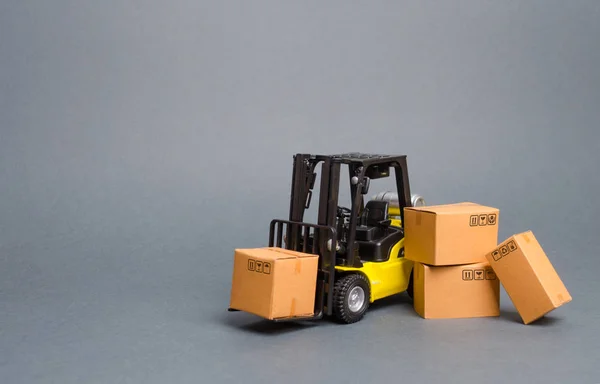 Camion stivuitor galben cu cutii de carton. Creșterea vânzărilor, producția de bunuri. transportul, depozitarea mărfurilor și a mărfurilor. Transport marfă, livrare de mărfuri. Logistică și infrastructură. Retailerul — Fotografie, imagine de stoc