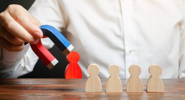 İşadamı bir mıknatıs ile takımdan kırmızı bir rakam çizer. lideri iş yönetir ve bir takım oluşturur. Toksik ve yetkili olmayan işçi kavramı. Takım verimliliğini ve üretkenliğini artırın.
