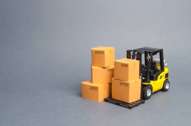 Karton kutular ile sarı Forklift kamyon. Bir ambar, teslimat ve ulaşım malların servis depolama. Kargo taşımacılığı, teslimat. İthalat ve ihracat, diğer ülkelerle emtia alışverişi