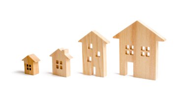 four wooden houses stand in ascending order on a white background. Isolate The concept of increasing population density and high-rise buildings. Agglomeration and urban growth. Selective focus clipart