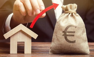 Bir para çantası ve evin yanında bir adamın elinde kırmızı bir ok. Gayrimenkul piyasasıbüyüme kavramı. Fiyat artışı. Bir ev veya daire satın almak için artan talep. Mortgage oranları artış