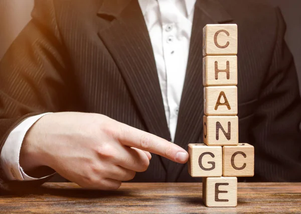 Businessman points to wooden blocks with the word Change to Chance. Personal development. Career growth or change yourself concept. Motivation, goal achievement, potential, incentive, overcoming