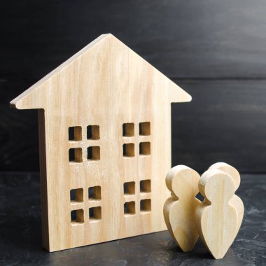 Bir grup insan binanın yanında duruyor. Gayrimenkul satın almak ya da satmak. Ev almak için borç veriyorum. Mülkiyet Derneği. Genç aileler için uygun fiyatlı ipotek. Kiralama veya satın alma