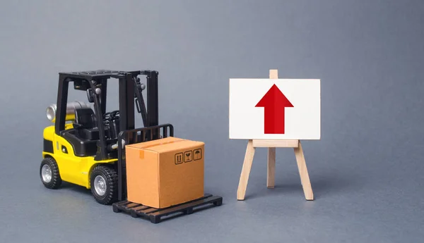 Sárga targonca hordozza egy doboz mellett egy festőállvány egy piros felfelé mutató nyilat. Az áruk és szolgáltatások termelésének üteme, a gazdasági jólét növelése. Kivitel, behozatal. eladások emelkedése. Magas kereskedelmi volumen — Stock Fotó