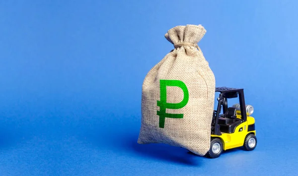 Yellow forklift truck carries bag of russian ruble money. Attracting investment in development, modernization of production and business. Revenue, profit, liquidity. profit fixation. capital migration