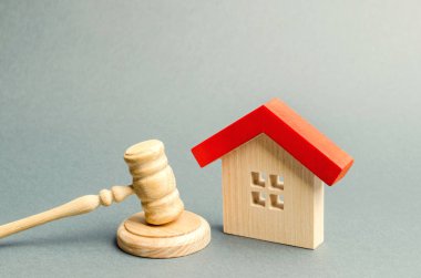 Miniature wooden house and judge's hammer. The concept of resolving property disputes. Property alienation. Confiscated housing. Nationalization. Services of a lawyer. Court. Gavel. Law clipart