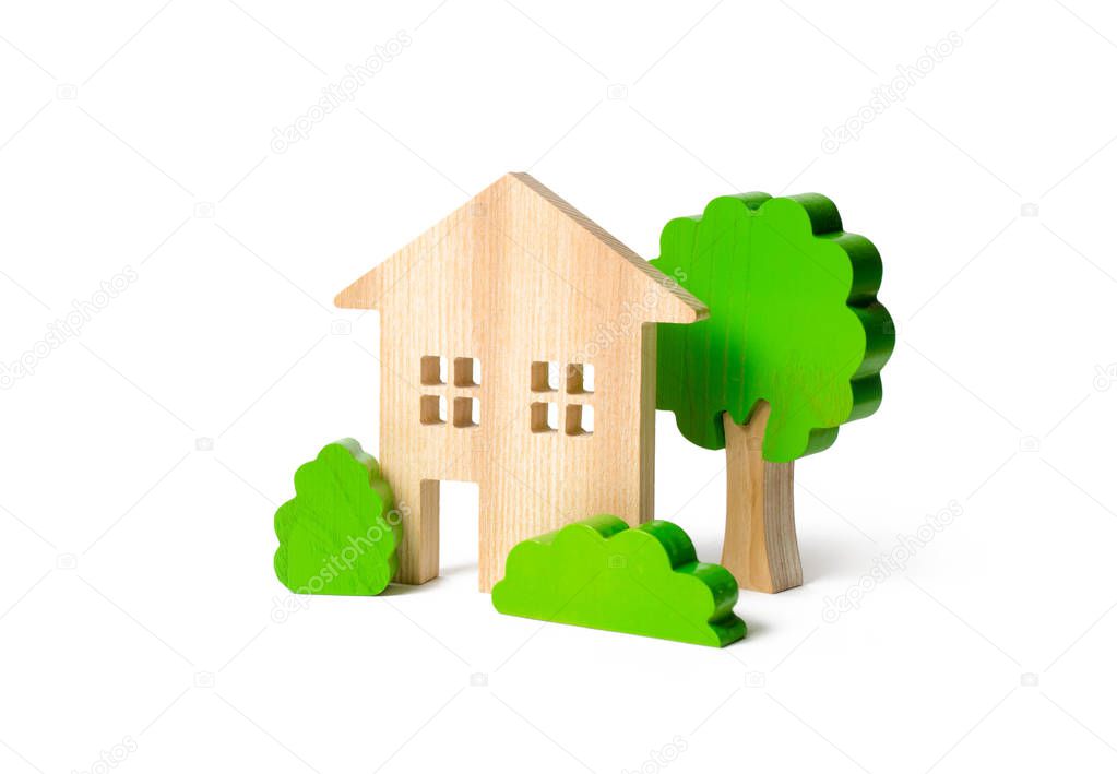 Large two-story house surrounded by bushes and trees on an isolated background. Urbanism and urban landscaping. Acquisition of affordable housing in a mortgage. Accommodation for families.