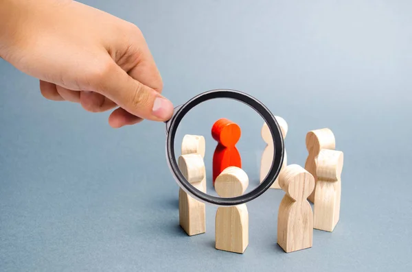 Lupa está mirando a la gente de pie en un círculo sobre un fondo gris. Comunicación. Equipo de negocios, trabajo en equipo, espíritu de equipo. Figuras de madera de la gente. Un círculo de personas. Enfoque selectivo —  Fotos de Stock