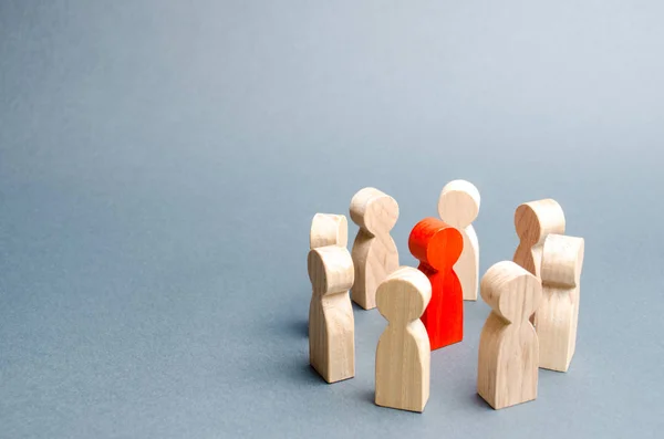 Ein Kreis von Menschen umgibt eine rote Person. Kommunikation. Business-Team, Teamwork, Teamgeist. Holzfiguren von Menschen. Ein Kreis von Menschen. Diskussion, Kooperation, Kooperation. Selektiver Fokus — Stockfoto